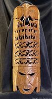 Full view of wooden African mask, displaying both human face and animal carvings.