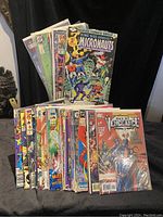 Front view of the 30 comic books mostly standing upright showing cover art from Marvel and DC titles including Micronauts Annual and Day of Vengeance.