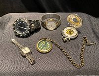 Lot overview showing all 5 watches on a textured fabric surface.