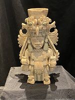 Front view of the ceramic vase showing the full figure with facial details and headdress.