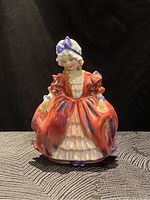 Front-facing view of Royal Doulton figurine showing detailed colorful dress and bonnet.
