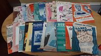 Full view of assorted vintage sheet music and songbooks spanning 1930s to 1950s, fanned out on table