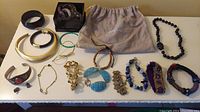 Overview of the full assortment of bracelets, earrings, and necklace spread on a table.