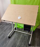 Top view showing flat wooden work surface with light marks and attached identification label.