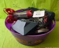View of two purple Halloween tubs containing bird feeders, including the glass globe feeder and red hummingbird feeder.