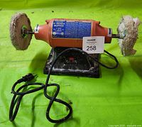 Front view of Central Machining electric 6-inch bench buffer showing orange housing, buffing wheels, power cord, and base.