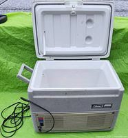 Front view of Coleman cooler warmer with lid open showing interior and power cord.