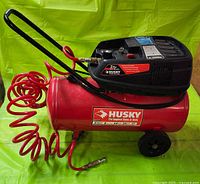 Side view showing compressor tank, motor housing, handle, wheels and attached hose