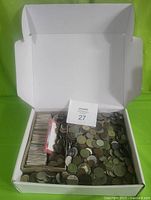 Open white box showing hundreds of coins loose and many coins in cardboard holders (2x2) and some plastic packaging inside the box.