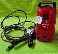 Front view of red Powerwasher pressure washer with hose and wand on a green surface.