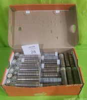 Nike shoebox with lid open showing 112 plastic coin tubes filled with pennies and loose stacks of pennies