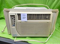 Front view of beige Fedders window air conditioner showing vent and control panel with power cord visible.