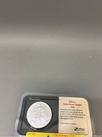 Obverse side of 2001 Silver American Eagle coin in packaging with card showing details and uncirculated condition.