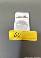 Photo showing front side of the encapsulated 2003 American Silver Eagle coin with grading label MS69 by NGC and auction lot number sticker.