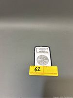 Front image of the 2008 US Silver Eagle coin in an NGC holder showing 'Gem Uncirculated' grade and lot number.