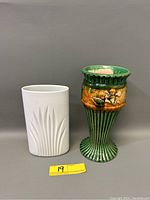 Green pedestal vase and white matte Rosenthal vase side by side with yellow lot tag