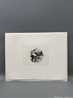 Front view of unframed etching on white background showing the detailed deformed head image centered on the paper with deckled edges.