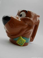 Side profile showing detailed sculpted head of Scooby Doo with blue collar and SD tag