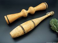 Photo of two wooden exercise aids side by side on a black background with a small plant in the corner. Shows overall size and shape of both items.