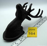 Side angled view showing the detailed cast iron deer head and measuring tape indicating size around 12 inches in height.