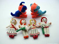 Photo showing all six crocheted vintage Christmas ornaments, including two dogs and four dolls, displayed upright.