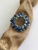 Blue rhinestone wreath brooch front view on wood background