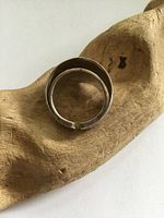 Ring shown from the top, highlighting the open-ended design and tarnish on the surface.