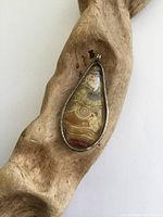 Front view of the vintage silver and agate drop pendant showing the agate stone with natural banding and silver bezel setting.