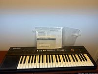 Full view of Casio Casitone CT-360 keyboard with manual on top.
