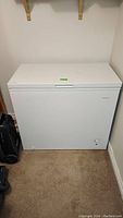 Full frontal photo of the white Frigidaire chest freezer closed, showing its rectangular shape and simple exterior.