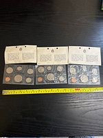 Three sealed plastic packages containing uncirculated Canadian coins from 1969 with informational header cards.