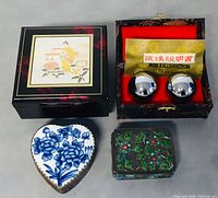 Photo showing all four items in the lot including three decorative Chinese trinket boxes and one boxed set of iron balls with instruction sheet.