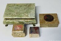 Top-front view showing all four onyx jewelry boxes of varying sizes arranged together on white surface.