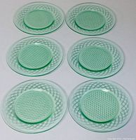 Six green diamond pattern Depression Glass plates arranged in two rows of three, showing consistent color and pattern across all plates.