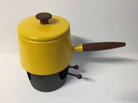 Side and top view of the yellow fondue pot with wooden handle and black metal stand including two fondue forks.