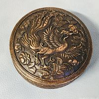 Top view of the copper trinket box showing the detailed peacock and floral embossed lid design.