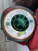 Close-up photo of an EZ-Roll all purpose light storage reel inside a red storage bag showing the label and construction of the reel.