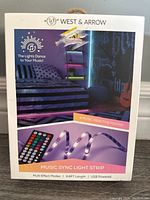 Front of box showing branding, music sync feature, and product image of LED light strip with remote.