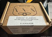 Closed cardboard box labeled DOHM Classic, gray color, YogaSleep website indication.