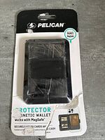 Front view of Pelican magnetic wallet in damaged packaging showing wallet inside and product information