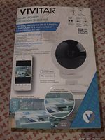 Box front showing Vivitar branding and product features - 360° wide-angle view, HD 1080p, pan/tilt/zoom, two-way intercom, night vision, smartphone app control compatible with iOS and Android.