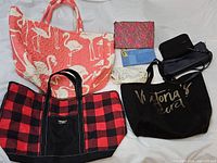 Overview of assorted bags and wallets with various patterns and brands including L.L.Bean and Victoria's Secret