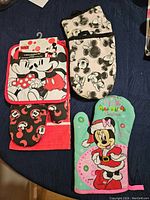 All four kitchen textile items with Mickey Mouse designs arranged on dark fabric