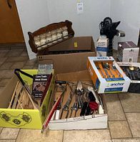 Overview of multiple boxes containing flatware, cooking utensils, spice rack, and more.