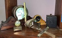 Overview photo showing the 2 mantle clocks, table clock, Brownie camera, and stereoscope on shelf
