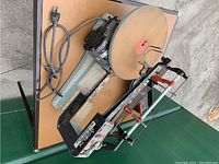 Delta electric scroll saw lying on its side showing the saw surface, arm, and power cord.