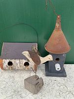 Front view of two folk art birdhouses and bird figure