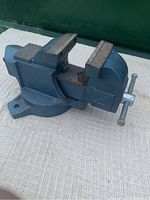 Blue heavy-duty No 4 bench vise with pivot feature on a textured light surface.