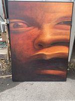 Full frontal view of the framed painting leaning outdoors