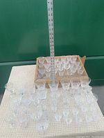 Top view showing a boxed set and loose crystal stemware laid out on a table with ruler for scale, including tall and short glasses.